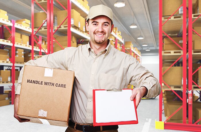 Smiling caucasian delivery man and 3d warehouse background